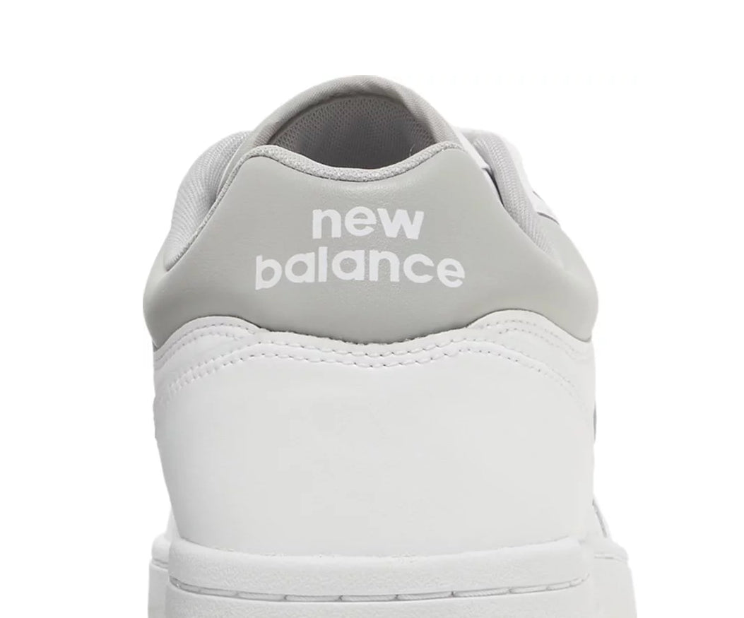 A white leather New Balance basketball shoe with gray accents.