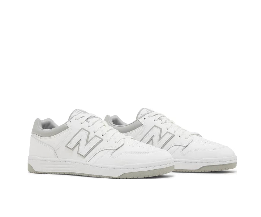 A white leather New Balance basketball shoe with gray accents.