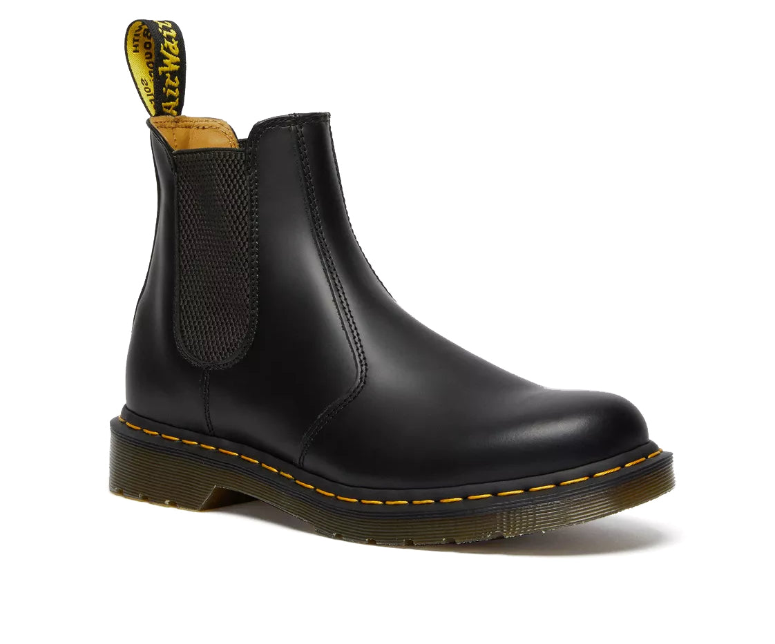 Side profile of a mid-ankle Dr. Martens black leather chelsea boot.