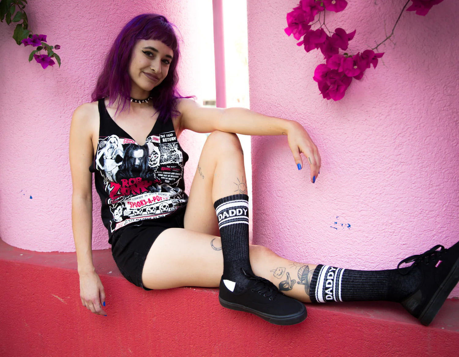 A woman wearing a pair of black and white crew socks that read "daddy."