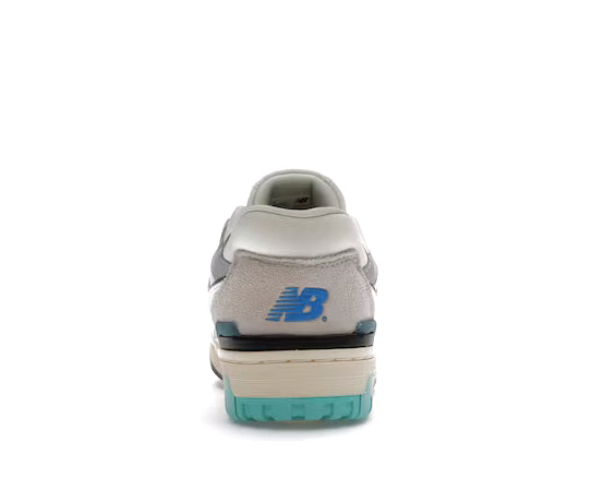 A white leather basketball sneaker with cyan and gold accents from New Balance.